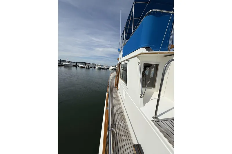 Slide: The Image of Side view of a 1999 Grand Banks 42 Classic yacht docked at a marina. - 13