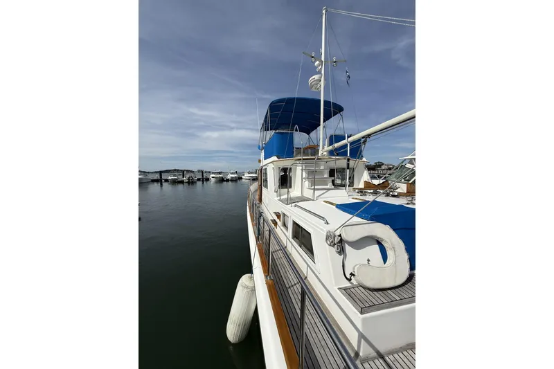 Slide: The Image of 1999 Grand Banks 42 Classic yacht docked at marina under clear sky. - 15
