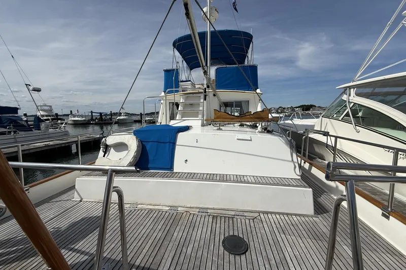 Slide: The Image of 1999 Grand Banks 42 Classic yacht docked at marina, featuring blue canopy and wooden deck. - 16