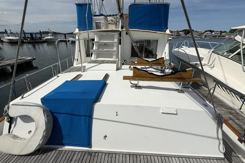 Slide: The Image of Grand Banks 42 Classic 1999 yacht docked at marina, featuring spacious deck and blue accents. - 17