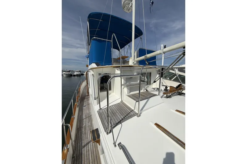 Slide: The Image of 1999 Grand Banks 42 Classic yacht with blue canopy, docked at marina. - 21