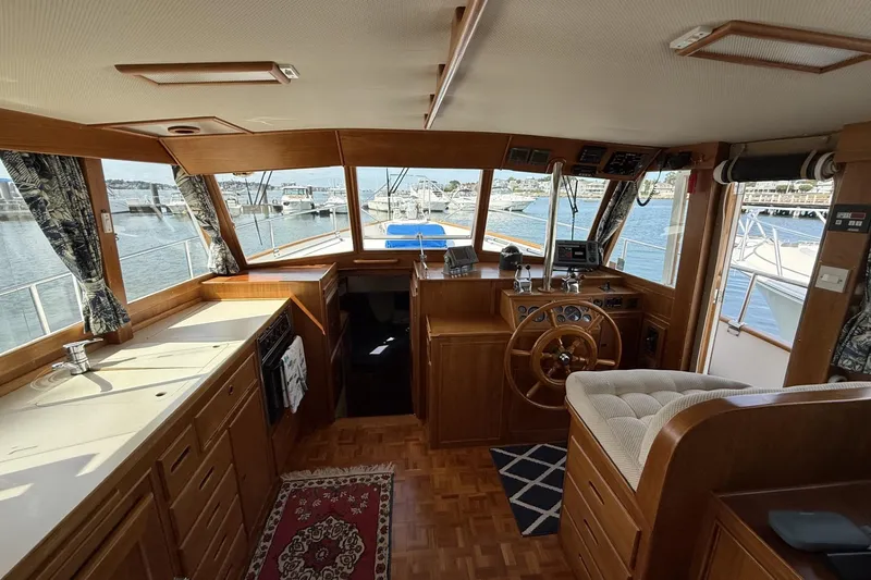 Slide: The Image of Interior of 1999 Grand Banks 42 Classic yacht with wooden helm and kitchen area. - 28