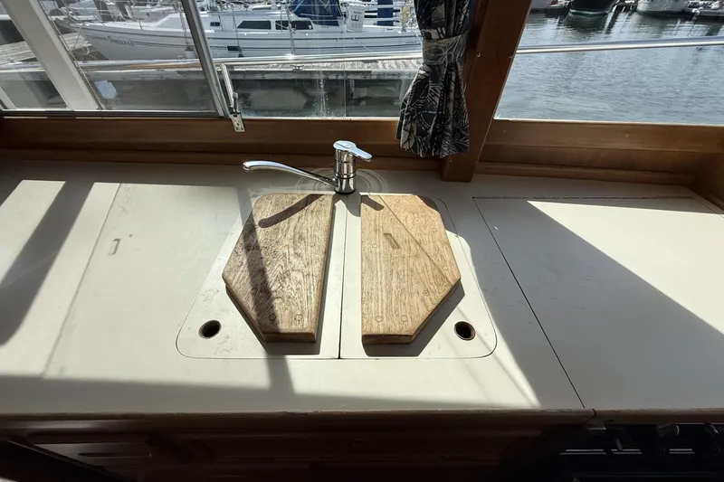 Slide: The Image of Kitchen sink area on a 1999 Grand Banks 42 Classic yacht with wooden covers. - 35