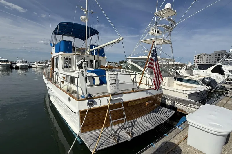 Slide: The Image of 1999 Grand Banks 42 Classic yacht docked at marina with American flag. - 4