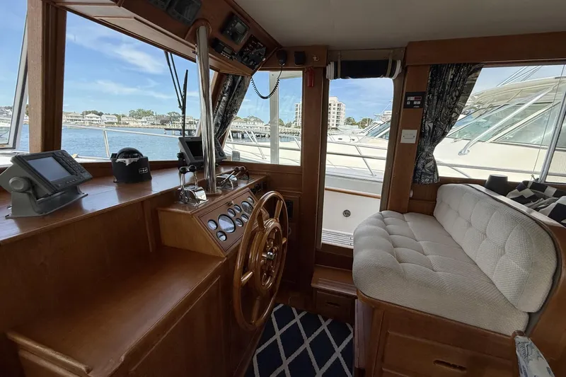 Slide: The Image of Interior of 1999 Grand Banks 42 Classic yacht with wooden helm and plush seating. - 40