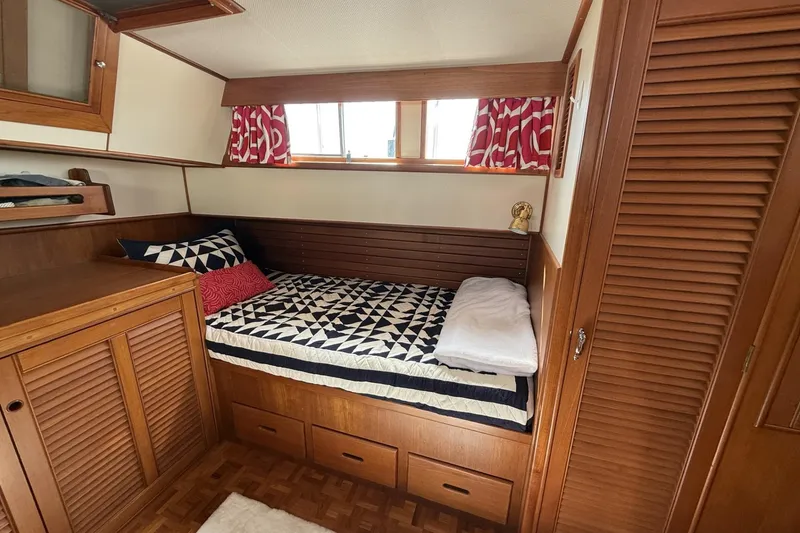 Slide: The Image of Cozy cabin interior of 1999 Grand Banks 42 Classic with wooden furnishings and patterned bedding. - 48