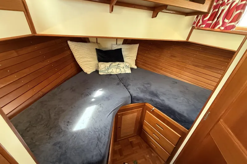 Slide: The Image of Cozy cabin interior of 1999 Grand Banks 42 Classic yacht with wooden paneling and bedding. - 55