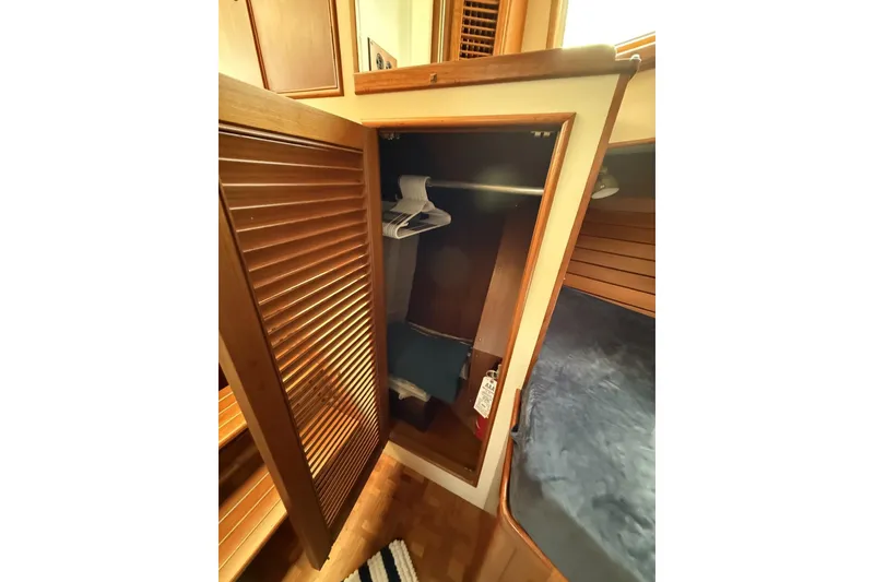 Slide: The Image of Wooden closet interior on 1999 Grand Banks 42 Classic yacht, featuring hangers and cozy cabin space. - 58