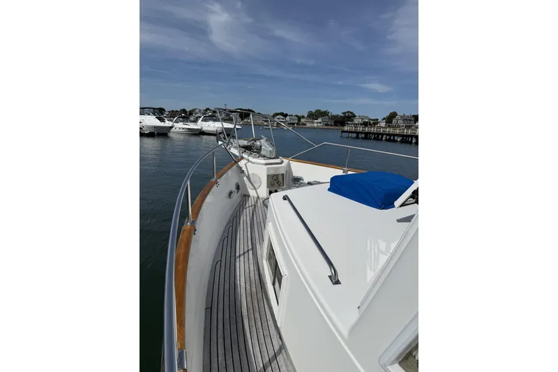 Slide: The Image of 1999 Grand Banks 42 Classic yacht docked in a marina, showcasing its elegant deck design. - 6