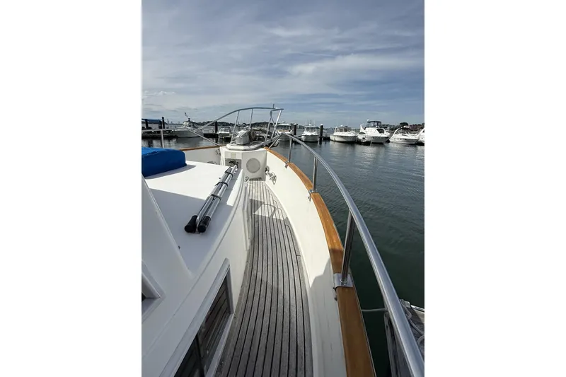 Slide: The Image of 1999 Grand Banks 42 Classic yacht docked at marina, showcasing deck and railing. - 7