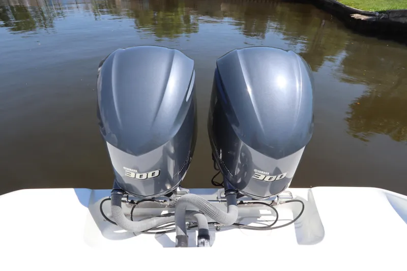 Slide: The Image of Twin Yamaha 300 engines on a 2013 Yellowfin 32 Offshore boat, docked on calm water. - 10