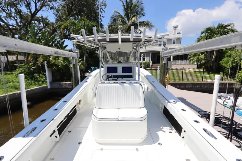Slide: The Image of 2013 Yellowfin 32 Offshore boat docked, featuring spacious seating and modern controls. - 14