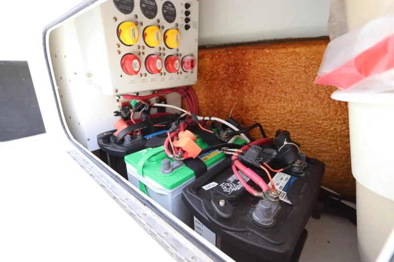 Slide: The Image of 2013 Yellowfin 32 Offshore boat battery compartment with wiring and control panel. - 25