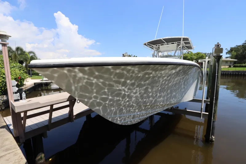 Slide: The Image of 2013 Yellowfin 32 Offshore boat docked, reflecting sunlight on calm water. - 3