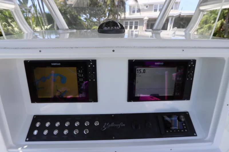 Slide: The Image of 2013 Yellowfin 32 Offshore boat dashboard with dual Simrad displays and control panel. - 34