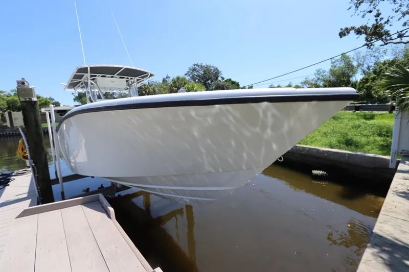 Slide: The Image of 2013 Yellowfin 32 Offshore boat docked in a serene canal setting. - 4
