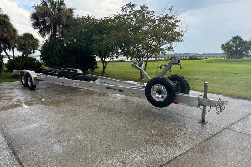 Slide: The Image of Trailer for 2013 Yellowfin 32 Offshore boat on wet driveway, surrounded by trees. - 49
