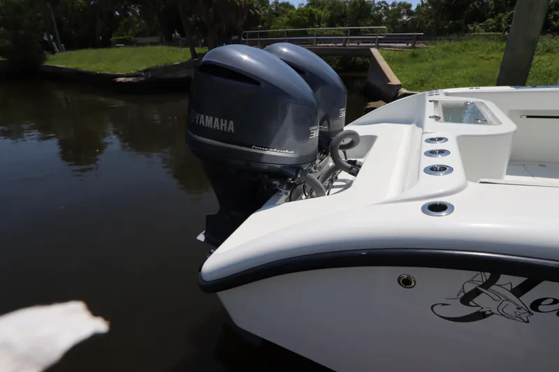 Slide: The Image of 2013 Yellowfin 32 Offshore boat with twin Yamaha engines docked by a riverbank. - 5