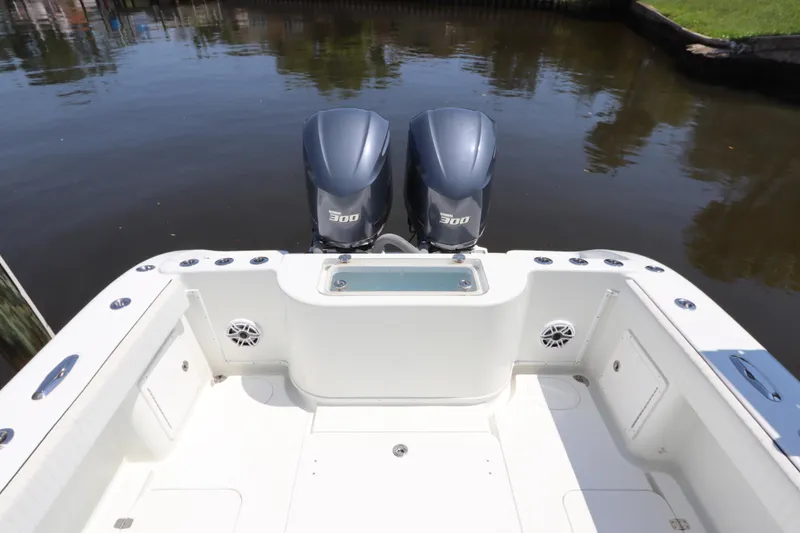 Slide: The Image of 2013 Yellowfin 32 Offshore boat with dual 300 horsepower engines, docked on calm water. - 7