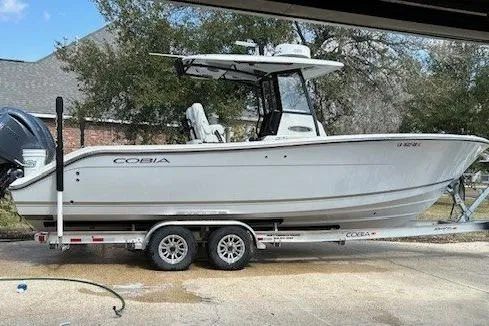 The Image of 2023 Cobia 280 Center Console boat on trailer, parked outdoors. - 0