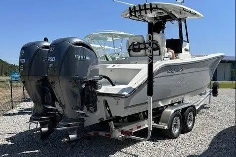 Slide: The Image of 2023 Cobia 280 Center Console boat with dual Yamaha engines on a trailer. - 2