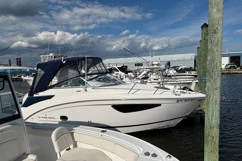 Slide: The Image of 2023 Regal 26 XO boat docked at marina under blue sky. - 0