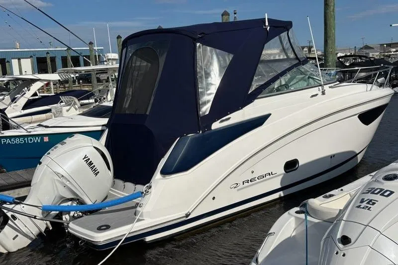 Slide: The Image of 2023 Regal 26 XO boat docked with Yamaha outboard engine, featuring a blue canopy. - 1