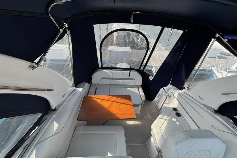 Slide: The Image of 2023 Regal 26 XO boat interior with seating and wooden table. - 10