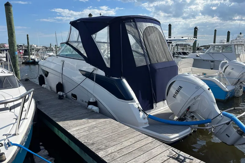 Slide: The Image of 2023 Regal 26 XO boat docked with Yamaha outboard motor, marina background. - 2