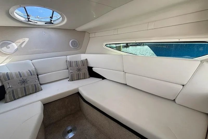 Slide: The Image of 2023 Regal 26 XO boat interior with white seating and nautical-themed pillows. - 21