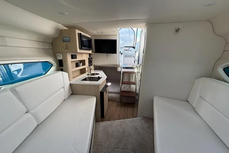 Slide: The Image of 2023 Regal 26 XO boat interior with modern kitchen, seating, and entertainment area. - 22