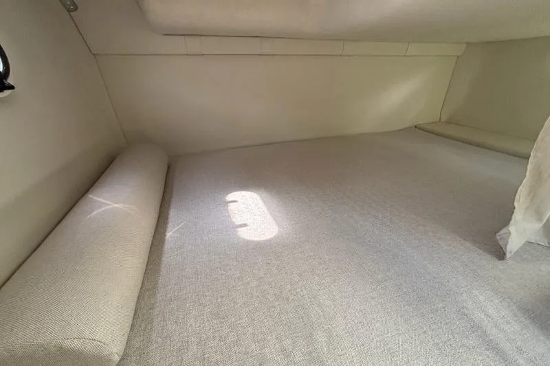 Slide: The Image of 2023 Regal 26 XO cabin interior with beige upholstery and soft lighting. - 24