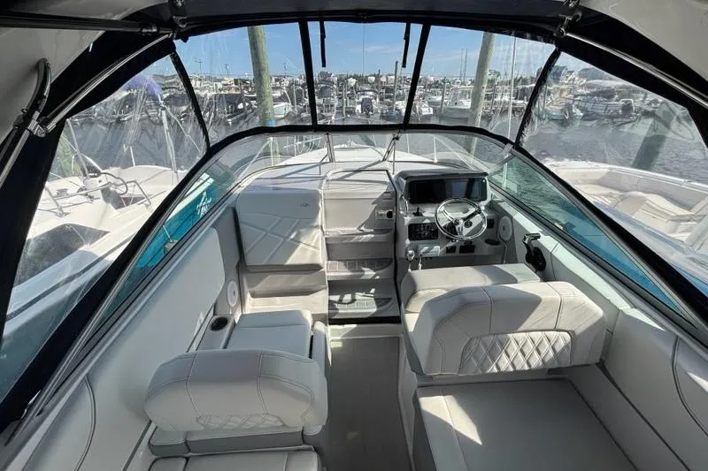 Slide: The Image of 2023 Regal 26 XO boat interior with modern helm and seating, docked at marina. - 5