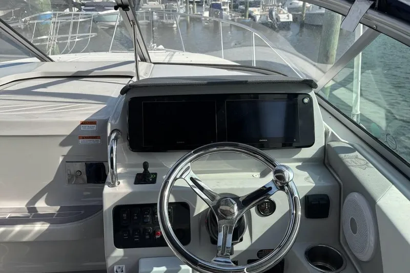 Slide: The Image of 2023 Regal 26 XO boat helm with steering wheel and navigation screens. - 7