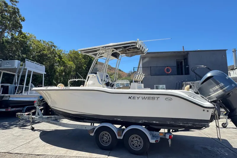 Slide: The Image of 2019 Key West 239 FS boat on trailer with Yamaha engine, parked outdoors. - 14