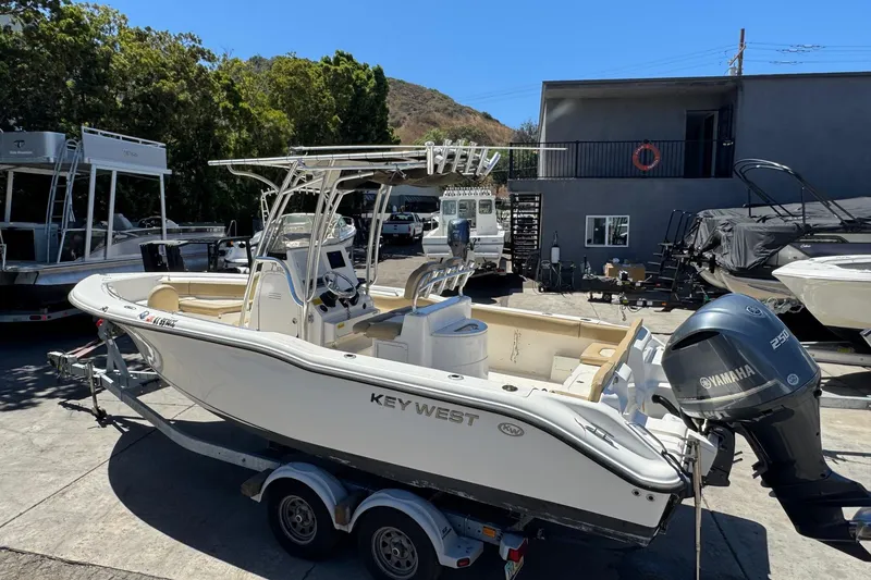 Slide: The Image of 2019 Key West 239 FS boat with Yamaha engine on trailer in marina setting. - 15