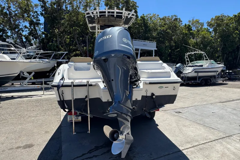 Slide: The Image of 2019 Key West 239 FS boat with Yamaha 250 engine, parked outdoors. - 9