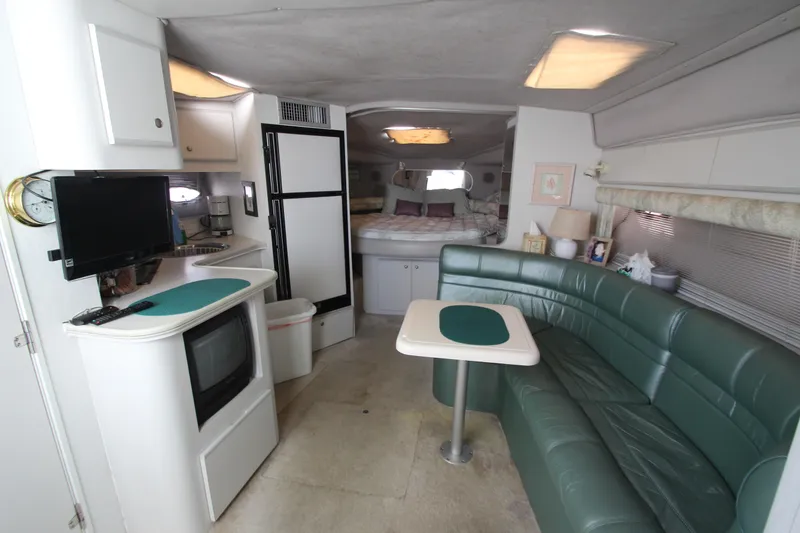 Slide: The Image of Interior of 1994 Cruisers Yachts Esprit 3775 with green seating, kitchenette, and cozy sleeping area. - 31