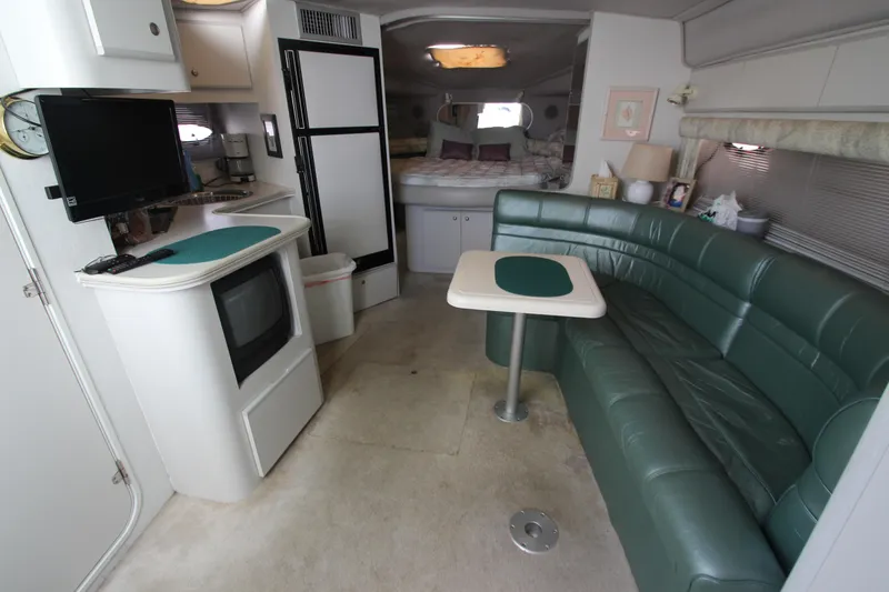 Slide: The Image of Interior of 1994 Cruisers Yachts Esprit 3775 with green seating and compact kitchen area. - 32
