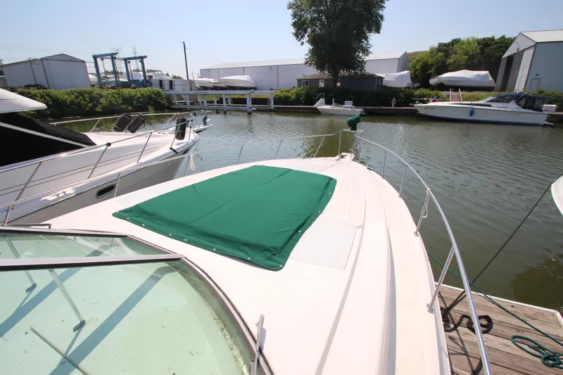Slide: The Image of 1994 Cruisers Yachts Esprit 3775 docked at marina, green cover on deck. - 3