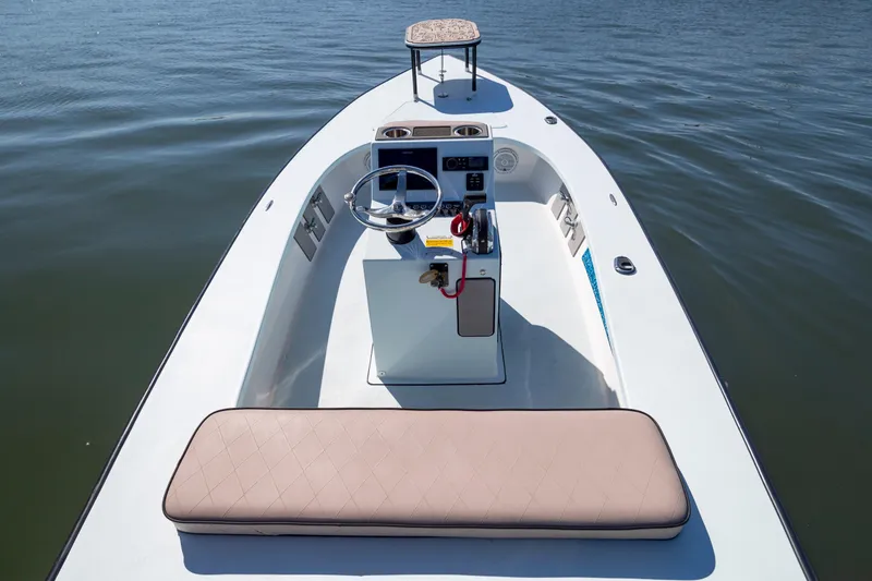 Slide: The Image of 2018 Xplor X18 boat interior with steering console and cushioned seating on calm water. - 10