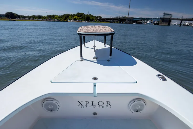 Slide: The Image of Bow view of 2018 Xplor X18 boat on calm water, featuring a raised platform. - 20