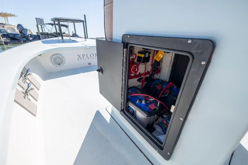 Slide: The Image of Open compartment on 2018 Xplor X18 boat showing battery and wiring. - 24