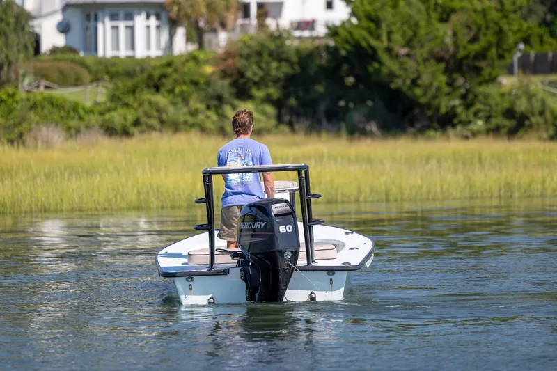 Slide: The Image of Man steering 2018 Xplor X18 boat with Mercury engine on calm water. - 4