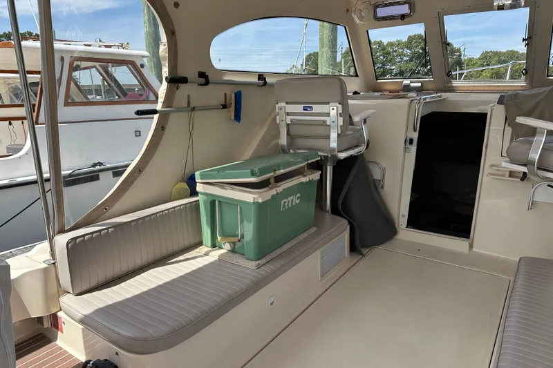 Slide: The Image of 2004 Mainship Pilot 30 boat interior with seating and cooler. - 10