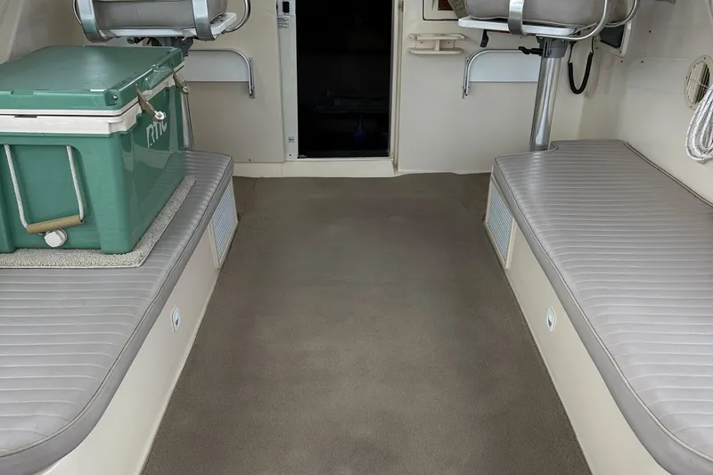 Slide: The Image of 2004 Mainship Pilot 30 interior with seating and a green cooler. - 12