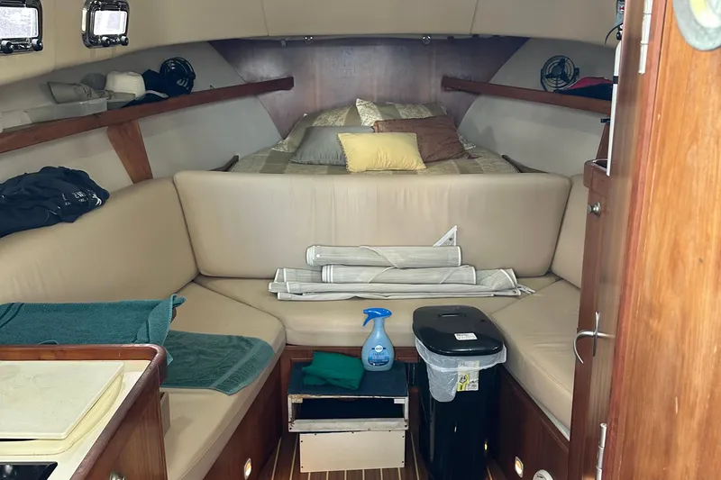 Slide: The Image of 2004 Mainship Pilot 30 cabin interior with seating, bed, and storage. - 13