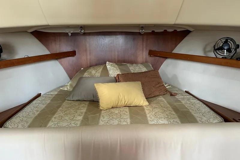 Slide: The Image of Cozy cabin interior of 2004 Mainship Pilot 30 with striped bedding and pillows. - 15