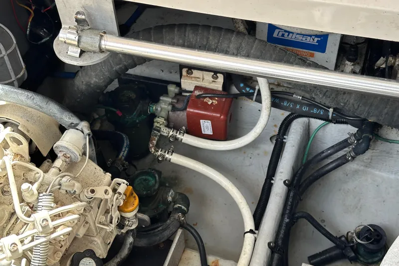 Slide: The Image of Engine compartment of a 2004 Mainship Pilot 30 boat, showing mechanical components and hoses. - 27