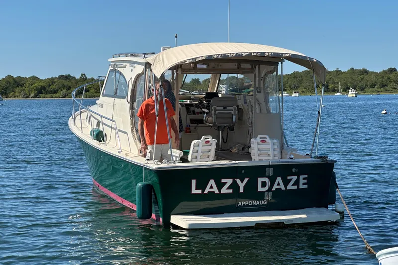 Slide: The Image of 2004 Mainship Pilot 30 boat named "Lazy Daze" on calm water. - 3